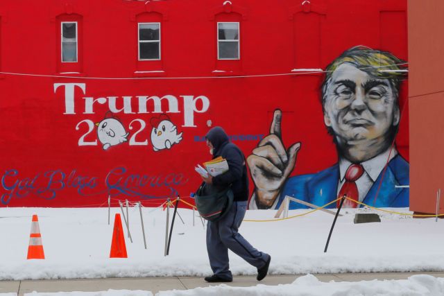 A mailman walks past a mural of U.S. President Donald Trump in Boone